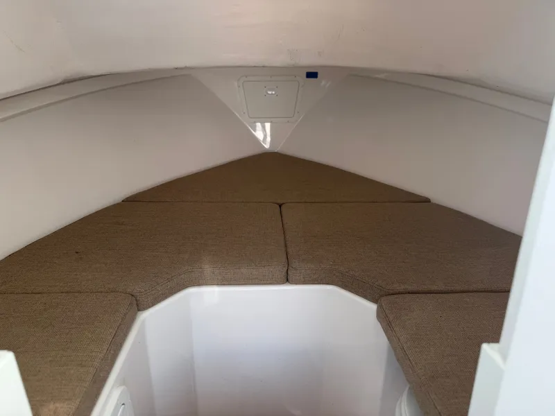 Slide: The Image of The cabin of the 2024 Steiger Craft 255 Miami features cushioned seating in a triangular layout. - 17