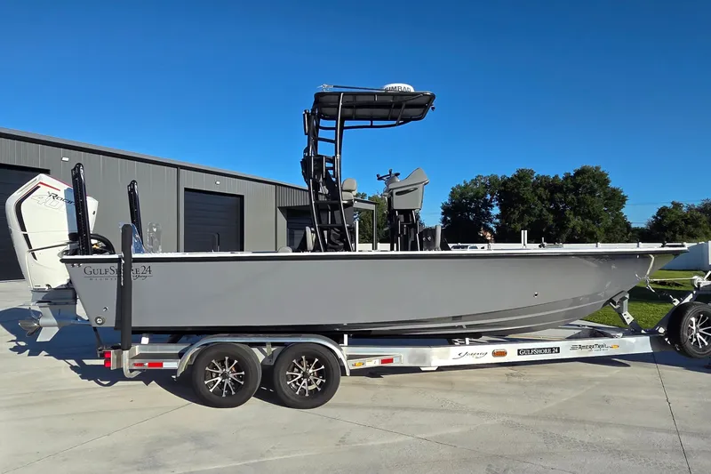 Slide: The Image of 2024 Young Boats 26 Gulfshore on trailer, parked outdoors near a building. - 15