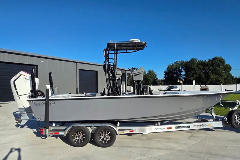 Slide: The Image of 2024 Young Boats 26 Gulfshore on trailer, parked outdoors near a building. - 16