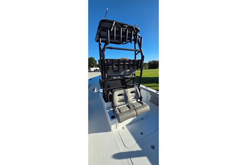 Slide: The Image of 2024 Young Boats 26 Gulfshore with elevated seating and storage, under clear blue sky. - 21
