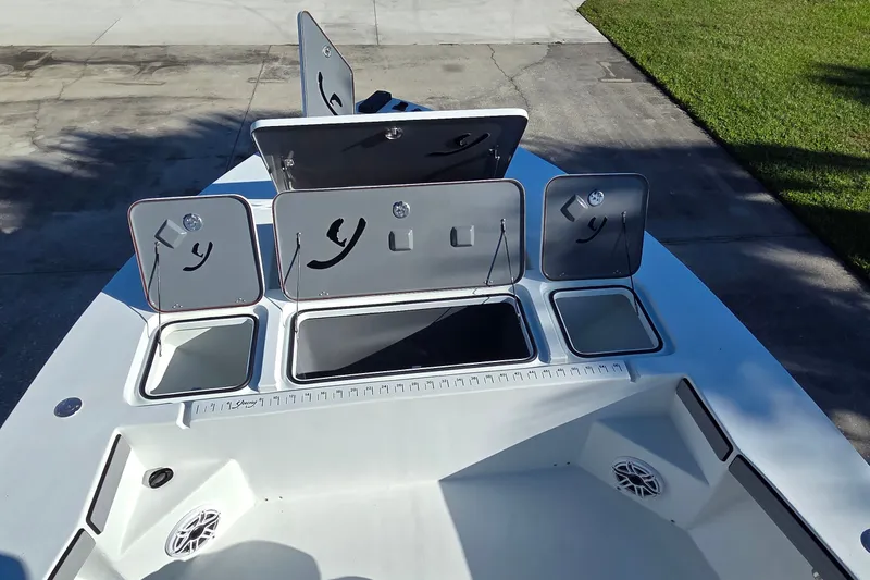 Slide: The Image of 2024 Young Boats 26 Gulfshore deck with open storage compartments and speakers. - 25