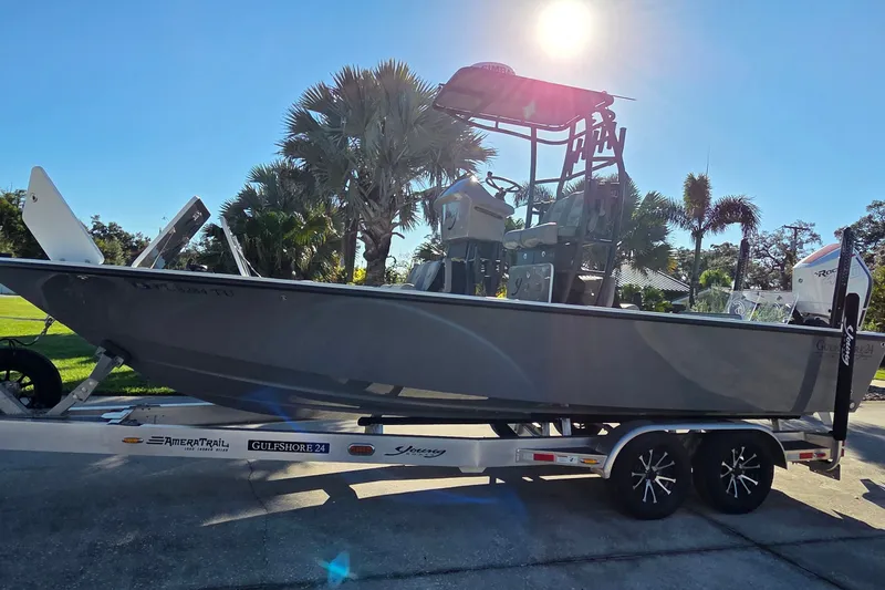 Slide: The Image of 2024 Young Boats 26 Gulfshore on trailer, sunny day, palm trees in background. - 29