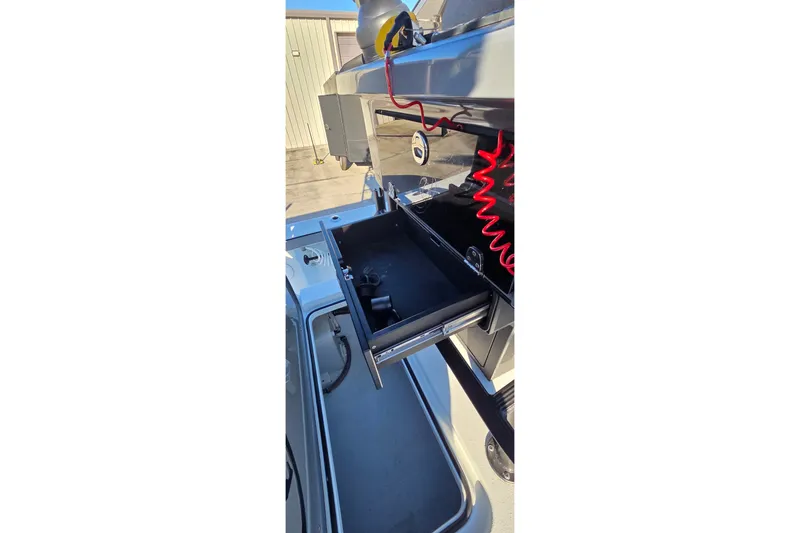 Slide: The Image of 2024 Young Boats 26 Gulfshore with open storage compartment and red coiled cable. - 22