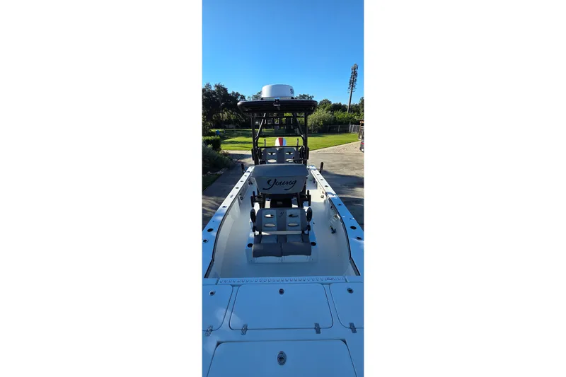 Slide: The Image of 2024 Young Boats 26 Gulfshore, sleek design, outdoor setting, clear blue sky. - 23