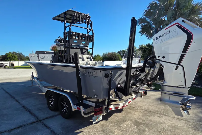 Slide: The Image of 2024 Young Boats 26 Gulfshore with powerful Racing 400 engine, parked on a trailer. - 27