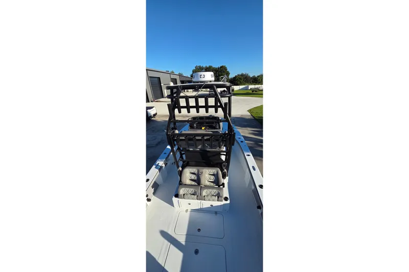 Slide: The Image of 2024 Young Boats 26 Gulfshore interior view with seating and equipment under clear blue sky. - 19