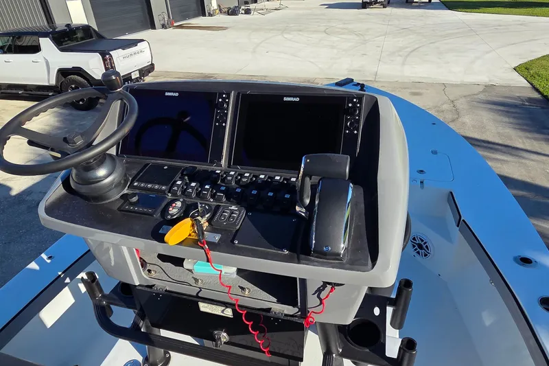 Slide: The Image of 2024 Young Boats 26 Gulfshore dashboard with steering wheel and navigation controls. - 24