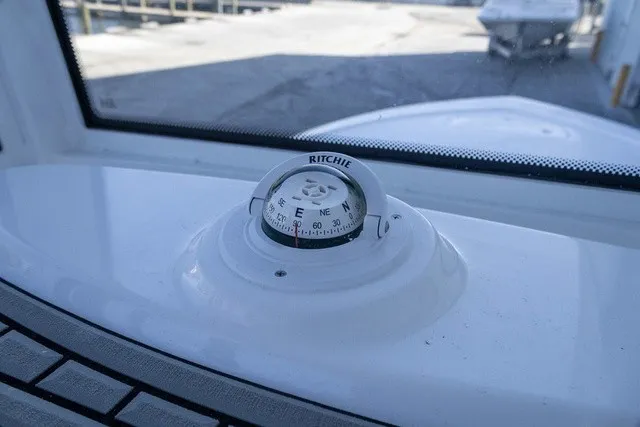 Slide: The Image of A compass is mounted on a boat's dashboard, overlooking a harbor area. - 6