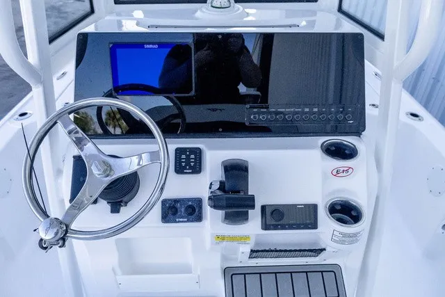 Slide: The Image of The image shows the helm of a Tidewater 2110 Bay Max boat. It features a steering wheel, electronic displays, and controls. - 7
