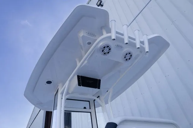Slide: The Image of The image shows the T-top of a Tidewater 2110 Bay Max boat with speakers and rod holders. - 9