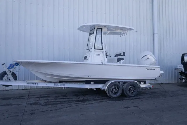The Image of A white Tidewater 2110 Bay Max boat from 2027 sits on a trailer in front of a warehouse. - 0