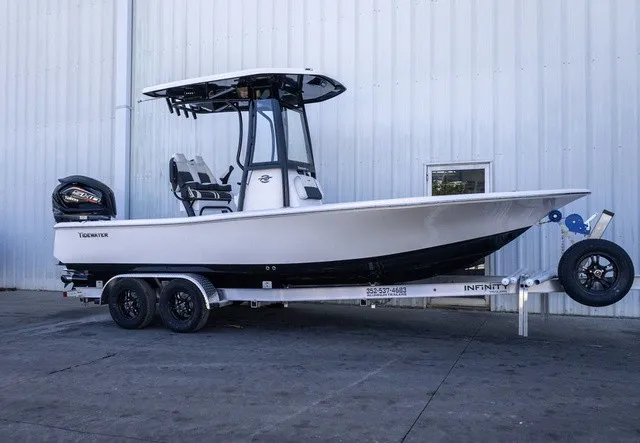 The Image of A white 2027 Tidewater 2210 Carolina Bay boat on a trailer in front of a building. - 0