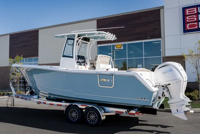 Slide: The Image of A modern 2027 Sea Hunt Ultra 265SE on a trailer in front of a building. - 4