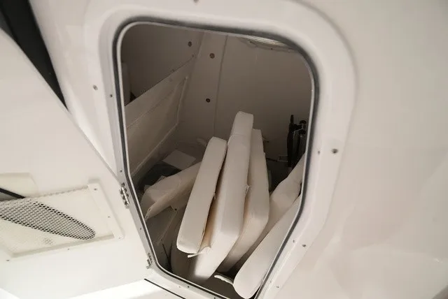 Slide: The Image of A storage compartment in the boat with several white cushions. - 19