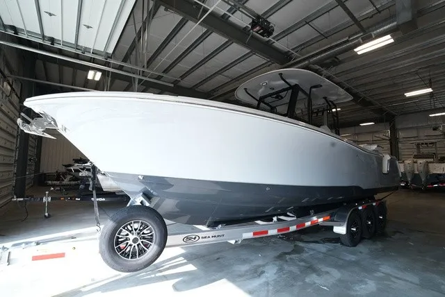 Slide: The Image of A 2027 Sea Hunt Ultra 285SE boat on a trailer inside a warehouse. - 1