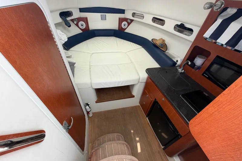 Slide: The Image of 2008 Pro-Line 32 Express cabin interior with bed, kitchenette, and wood accents. - 28