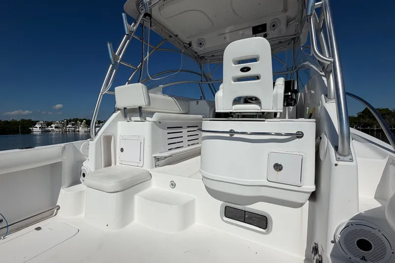 Slide: The Image of 2008 Pro-Line 32 Express boat interior with seating and helm, docked by calm waters. - 13