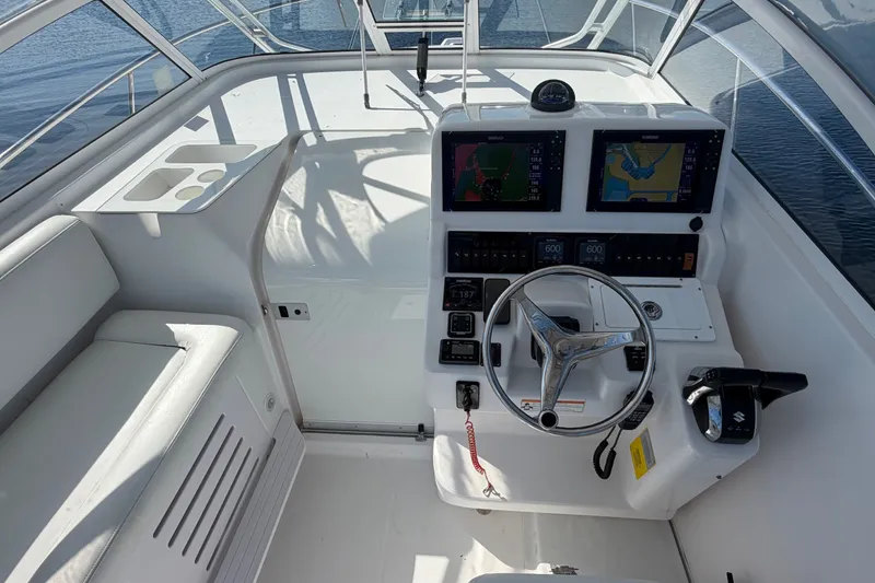 Slide: The Image of 2008 Pro-Line 32 Express boat cockpit with dual navigation screens and steering wheel. - 16