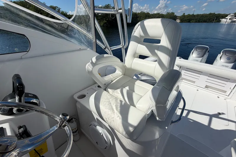 Slide: The Image of Captain's chair on 2008 Pro-Line 32 Express boat, overlooking serene water and powerful engines. - 24