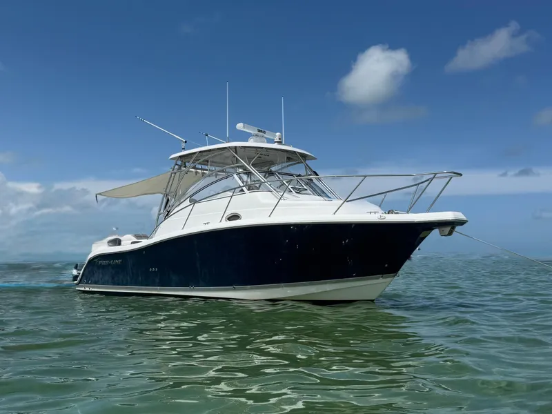 Slide: The Image of Ein Pro-Line 32 Express Boot von 2008 schwimmt auf ruhigem Wasser unter blauem Himmel. - 2