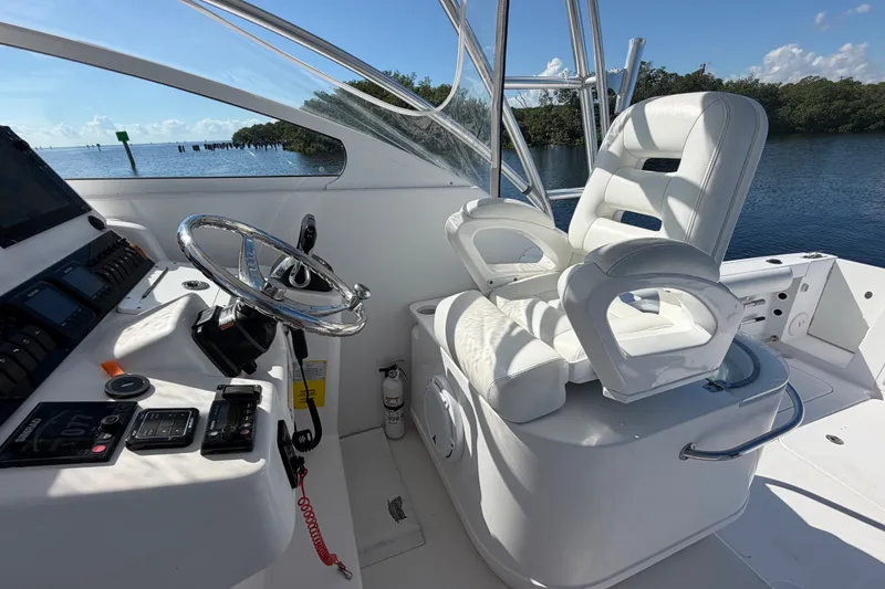 Slide: The Image of 2008 Pro-Line 32 Express boat helm with white seating and steering wheel. - 23