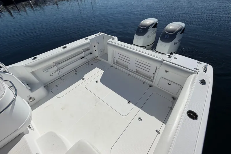 Slide: The Image of 2008 Pro-Line 32 Express boat deck with twin Suzuki outboard motors, docked on calm water. - 11