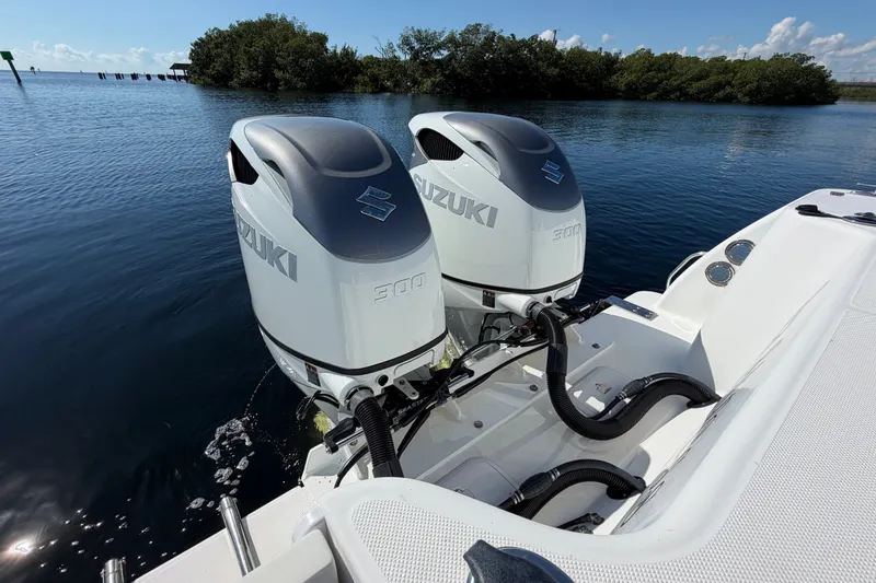 Slide: The Image of Twin Suzuki 300 outboard engines on a 2008 Pro-Line 32 Express boat in calm waters. - 9