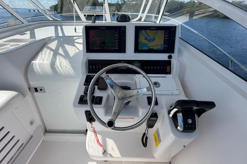 Slide: The Image of 2008 Pro-Line 32 Express boat helm with dual navigation screens and steering wheel. - 14