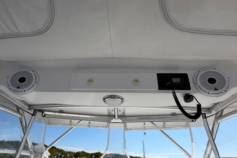 Slide: The Image of 2008 Pro-Line 32 Express boat interior with speakers and radio system under clear sky. - 22