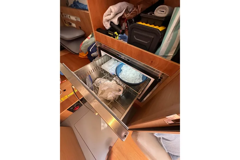 Slide: The Image of Interior of 2024 Jeanneau Sun Odyssey 410 with open drawer and storage items. - 57