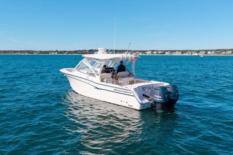 Slide: The Image of 2014 Grady-White Freedom 307 boat on open water, clear sky, distant shoreline. - 13