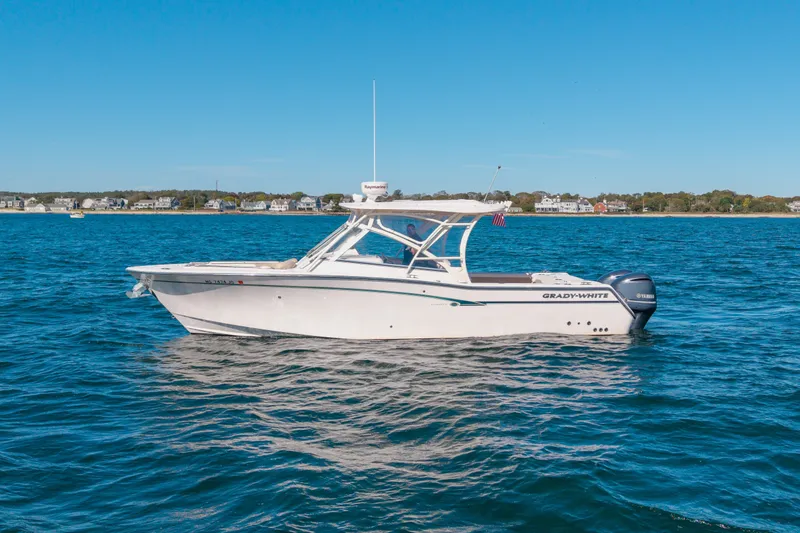 Slide: The Image of 2014 Grady-White Freedom 307 boat cruising on a clear blue ocean near the shoreline. - 10