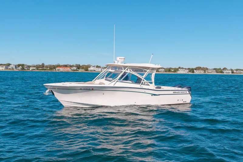 Slide: The Image of 2014 Grady-White Freedom 307 boat on calm blue water, coastal homes in background. - 8