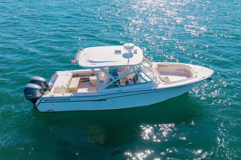 Slide: The Image of 2014 Grady-White Freedom 307 boat cruising on sparkling blue water. - 53