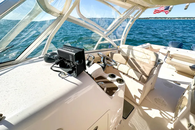 Slide: The Image of 2014 Grady-White Freedom 307 boat interior with Garmin navigation, cruising on open water. - 30