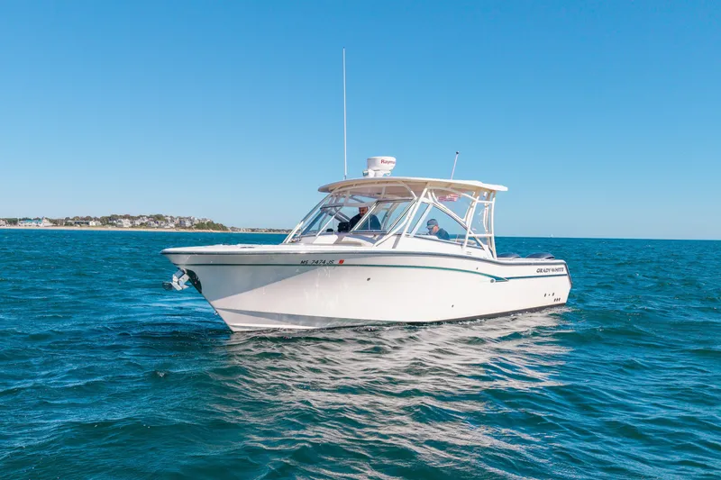 Slide: The Image of 2014 Grady-White Freedom 307 boat cruising on open water under clear blue sky. - 11