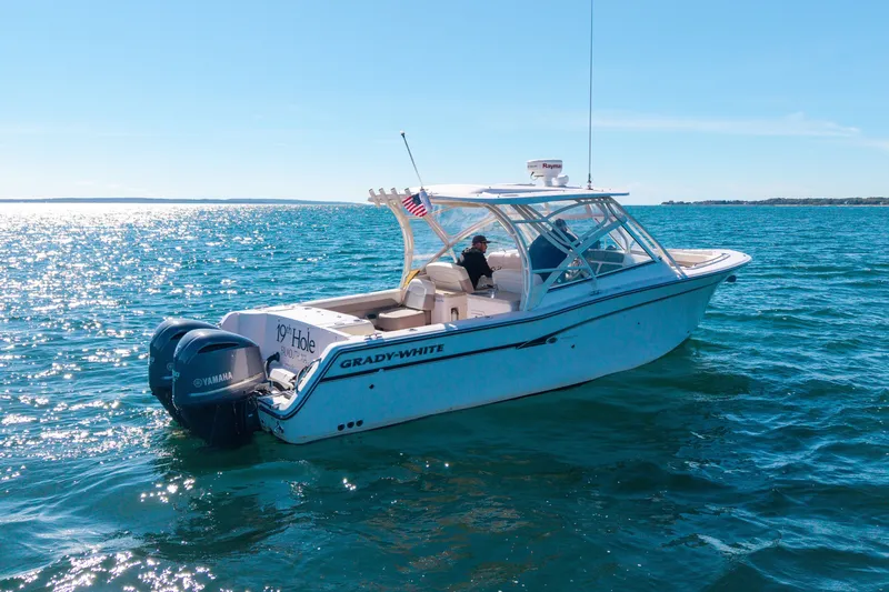 Slide: The Image of 2014 Grady-White Freedom 307 boat cruising on open water under clear blue skies. - 15