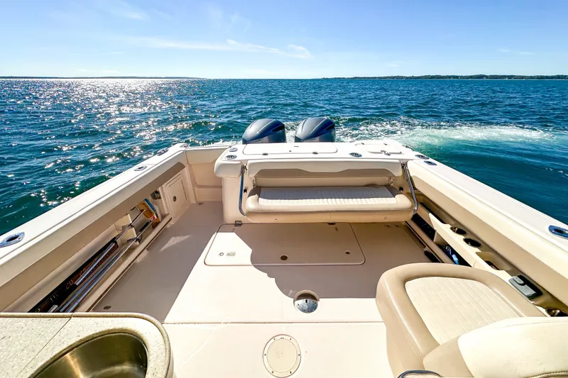 Slide: The Image of 2014 Grady-White Freedom 307 boat on open water, sunny day, spacious deck. - 32