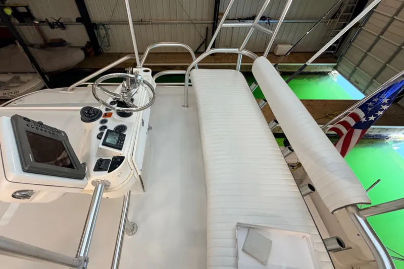 Slide: The Image of 2003 Luhrs 36 Open boat helm with steering wheel, navigation equipment, and seating in a marina. - 32