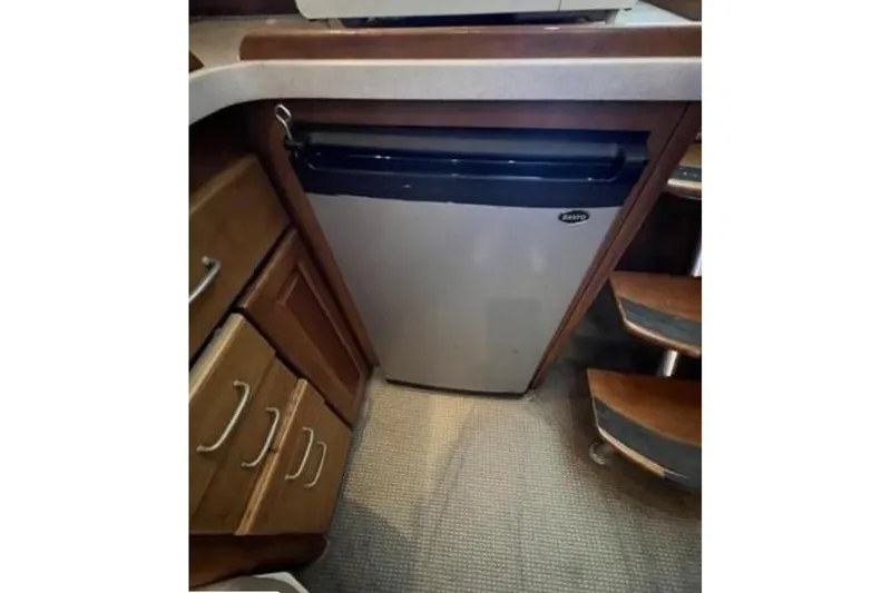 Slide: The Image of Compact kitchen area in 2003 Luhrs 36 Open boat with fridge and wooden cabinetry. - 17