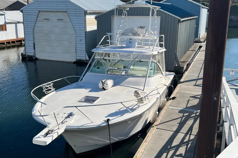 Slide: The Image of 2003 Luhrs 36 Open boat docked beside boathouses on a sunny day. - 46