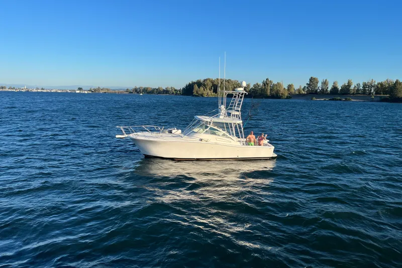 Slide: The Image of 2003 Luhrs 36 Open boat cruising on a serene lake under a clear blue sky. - 41