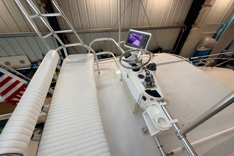 Slide: The Image of 2003 Luhrs 36 Open boat helm with steering wheel, controls, and navigation screen in a marina setting. - 36