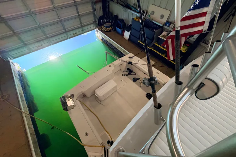 Slide: The Image of 2003 Luhrs 36 Open boat docked in a garage with fishing rods and American flag. - 35