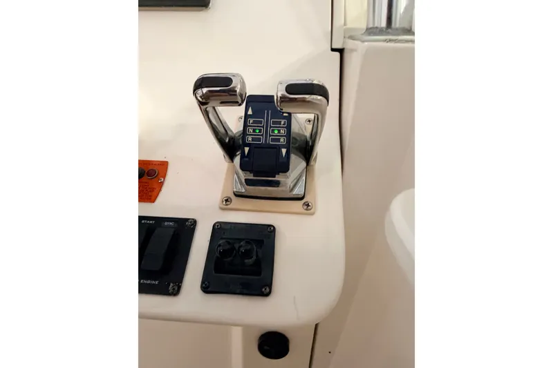 Slide: The Image of Control panel of a 2003 Luhrs 36 Open boat, featuring throttle and switches. - 20