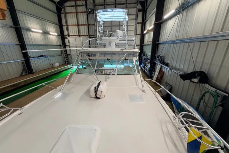 Slide: The Image of 2003 Luhrs 36 Open boat in indoor storage, showcasing deck and tower. - 27