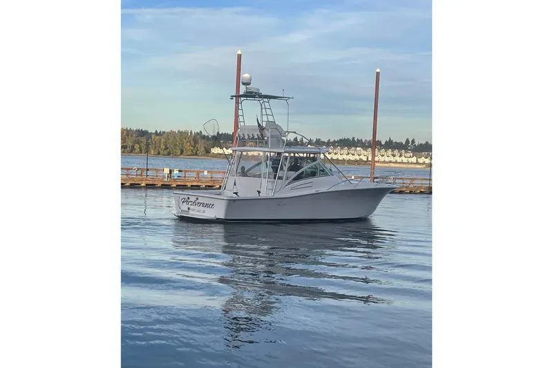 Slide: The Image of 2003 Luhrs 36 Open boat on calm water, dock and trees in background. - 49
