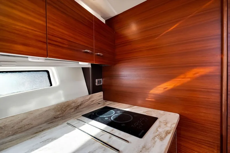 Slide: The Image of Luxurious 2017 Pursuit SC 365i Sport Coupe kitchen with sleek wood cabinetry and modern cooktop. - 28