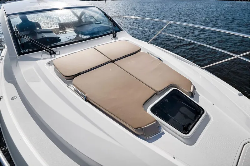 Slide: The Image of 2017 Pursuit SC 365i Sport Coupe with sunpad on deck, overlooking water. - 14