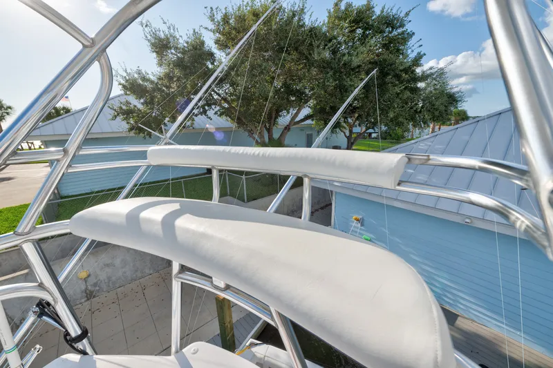 Slide: The Image of 2005 Cabo 35 Express boat tower with seating, surrounded by trees and buildings. - 18